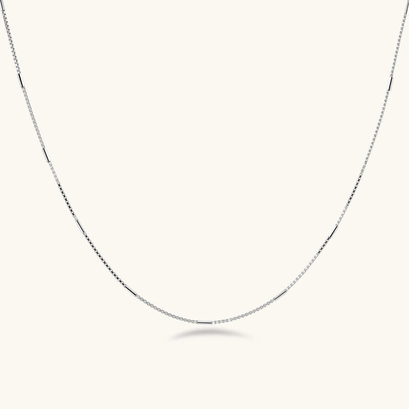 Delicate platinum-plated sterling silver necklace with alternating textured cubic links and smooth chain sections.